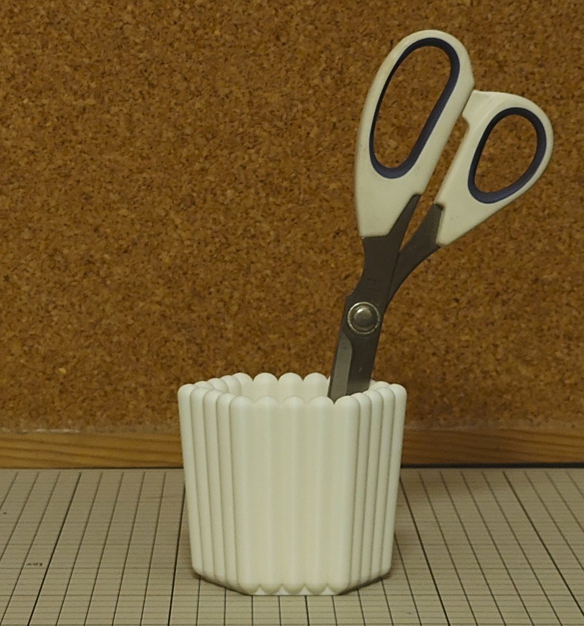 裁ちばさみがペン立てにほぼ垂直に差されている