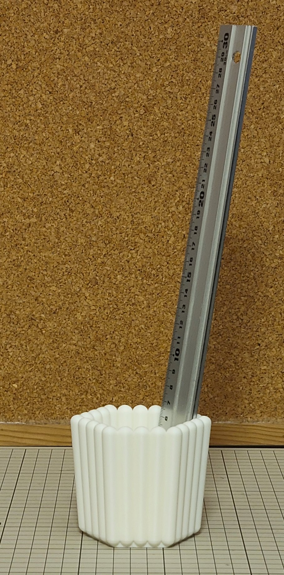 ものさしがペン立てにほぼ垂直に差されている