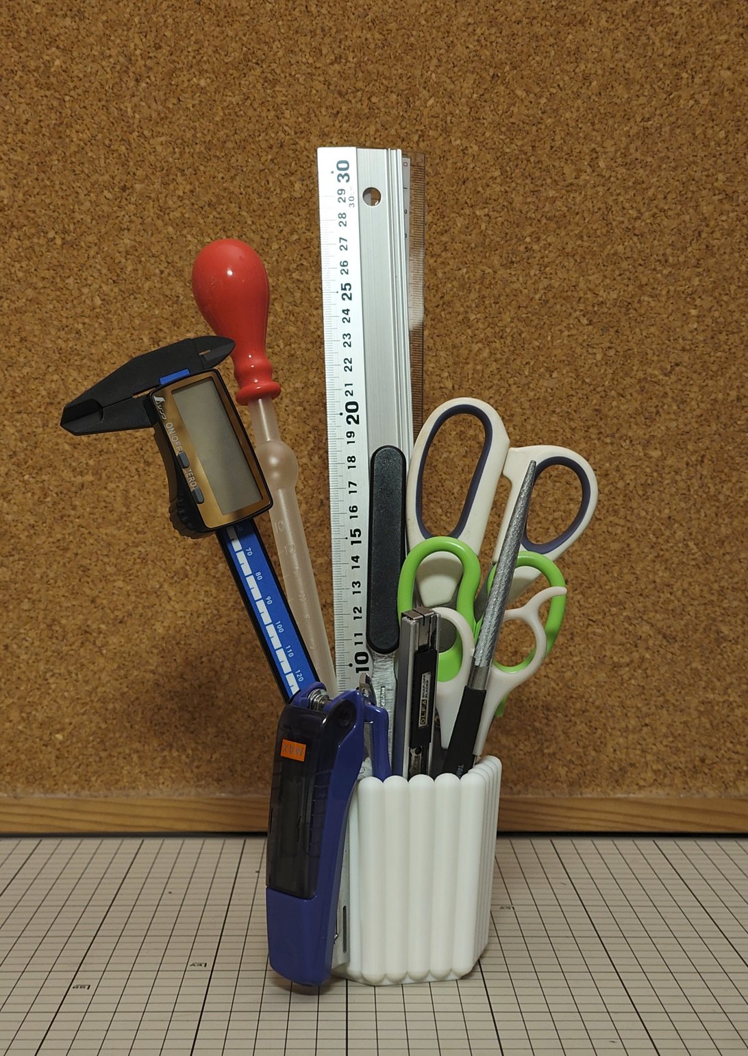 ペン立てにいろいろな文房具が差さっている